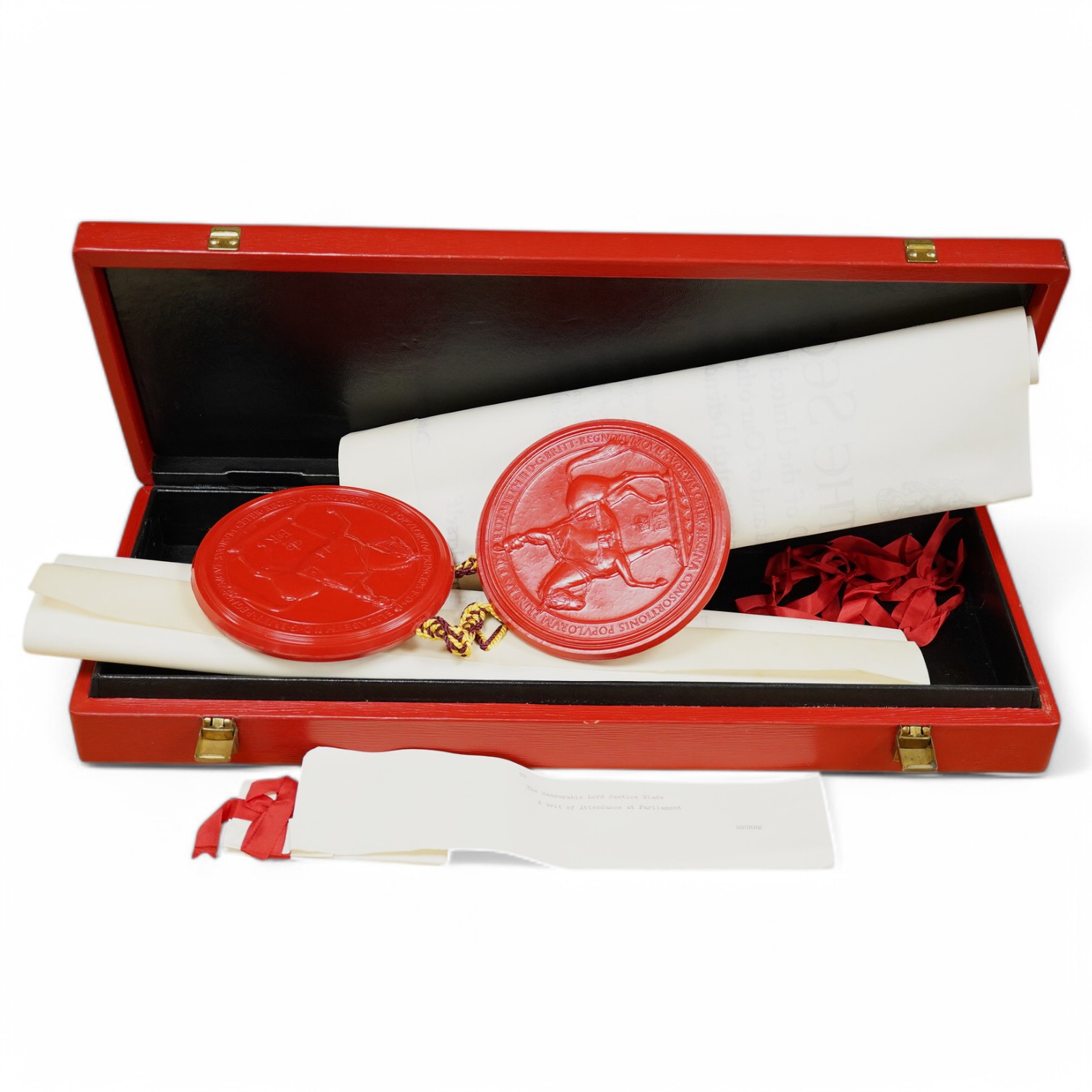 The Hon. Lord Justice Slade, ‘A Writ of Attendance at Parliament’, two vellum documents with ERII red seals in a red fitted case with a gold Royal Coat of Arms stamp, case 59cm wide x 23cm deep. Condition - some foxing